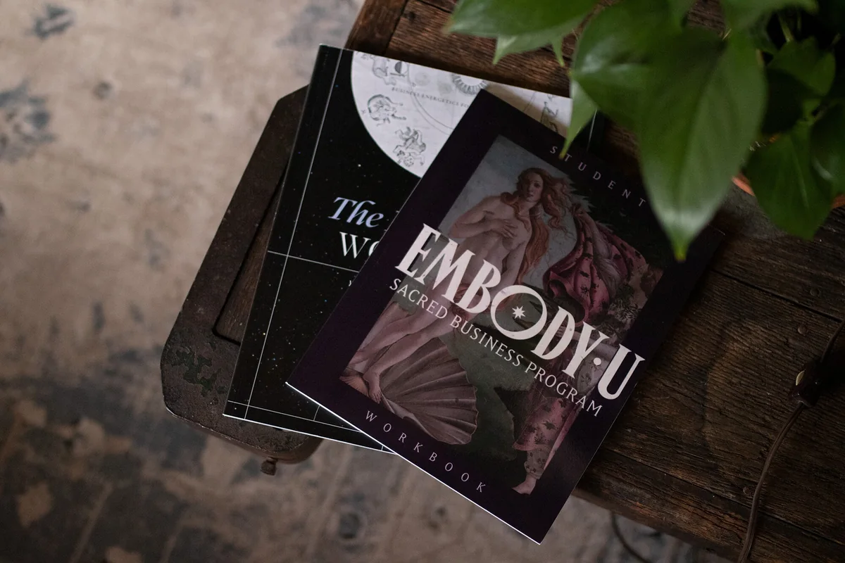 The Embody U student workbook and course books on a wooden table